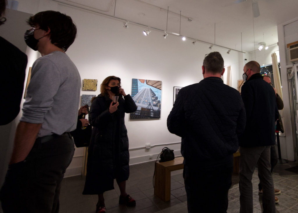 Group of people facing a wall with artwork hanging